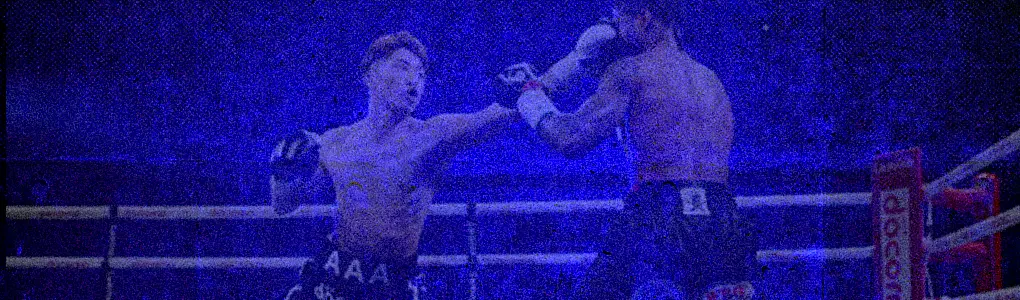Blue-toned-boxing-action-shot-with-one-fighter-landing-a-punch-inside-a-brightly-lit-ring_