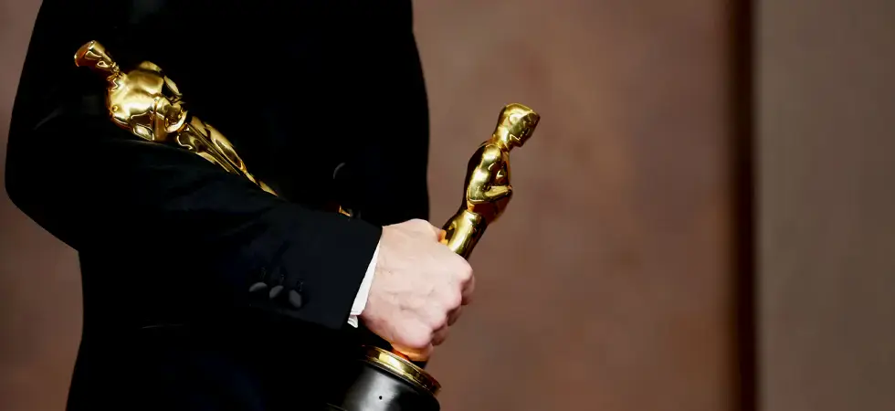 A-person-with-2-Oscar-awards-in-his-hands